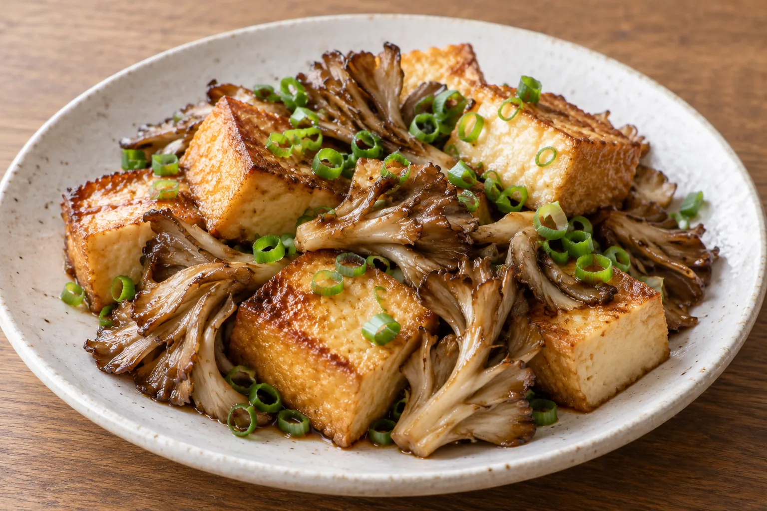 焼き色のついた厚揚げと舞茸にバター醤油のタレを絡め、青ねぎを散らした一皿